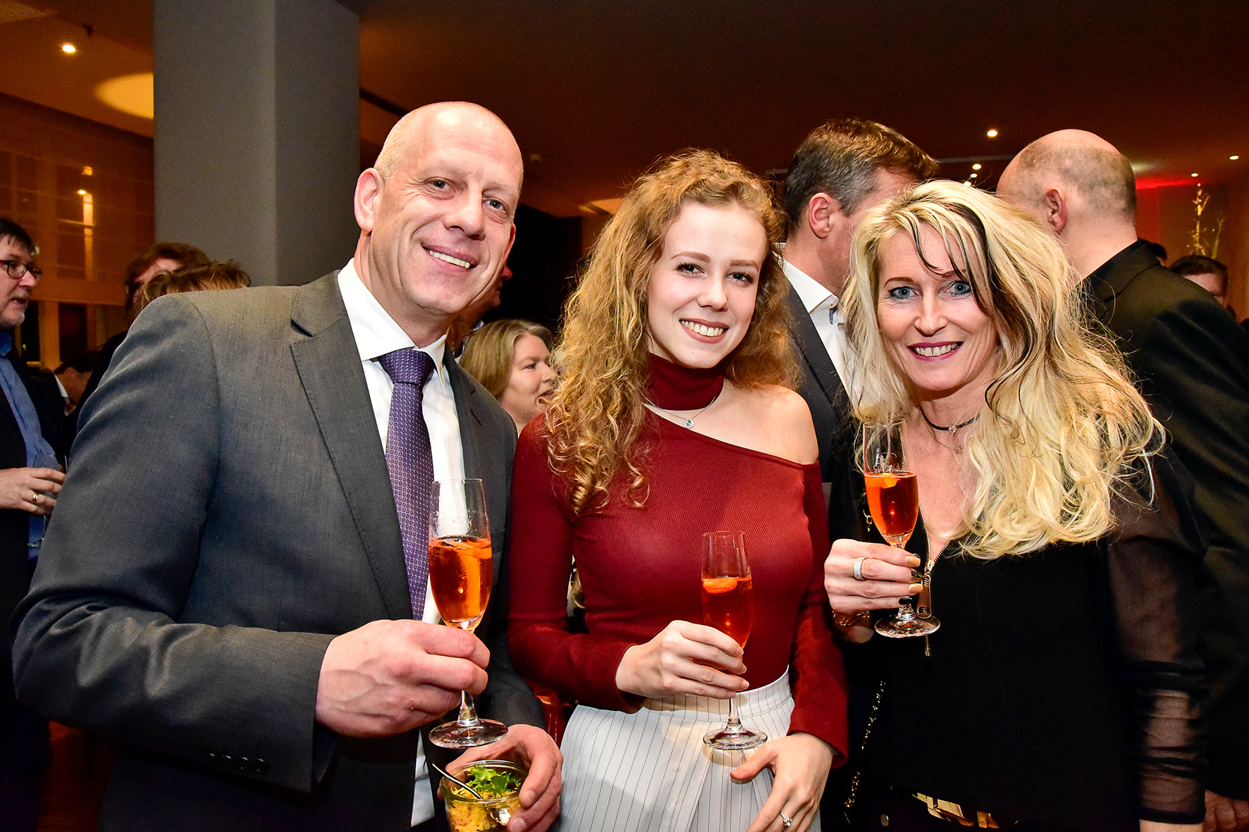 Zwei Frauen und ein Mann beim Film-Award lächeln in die Kamera