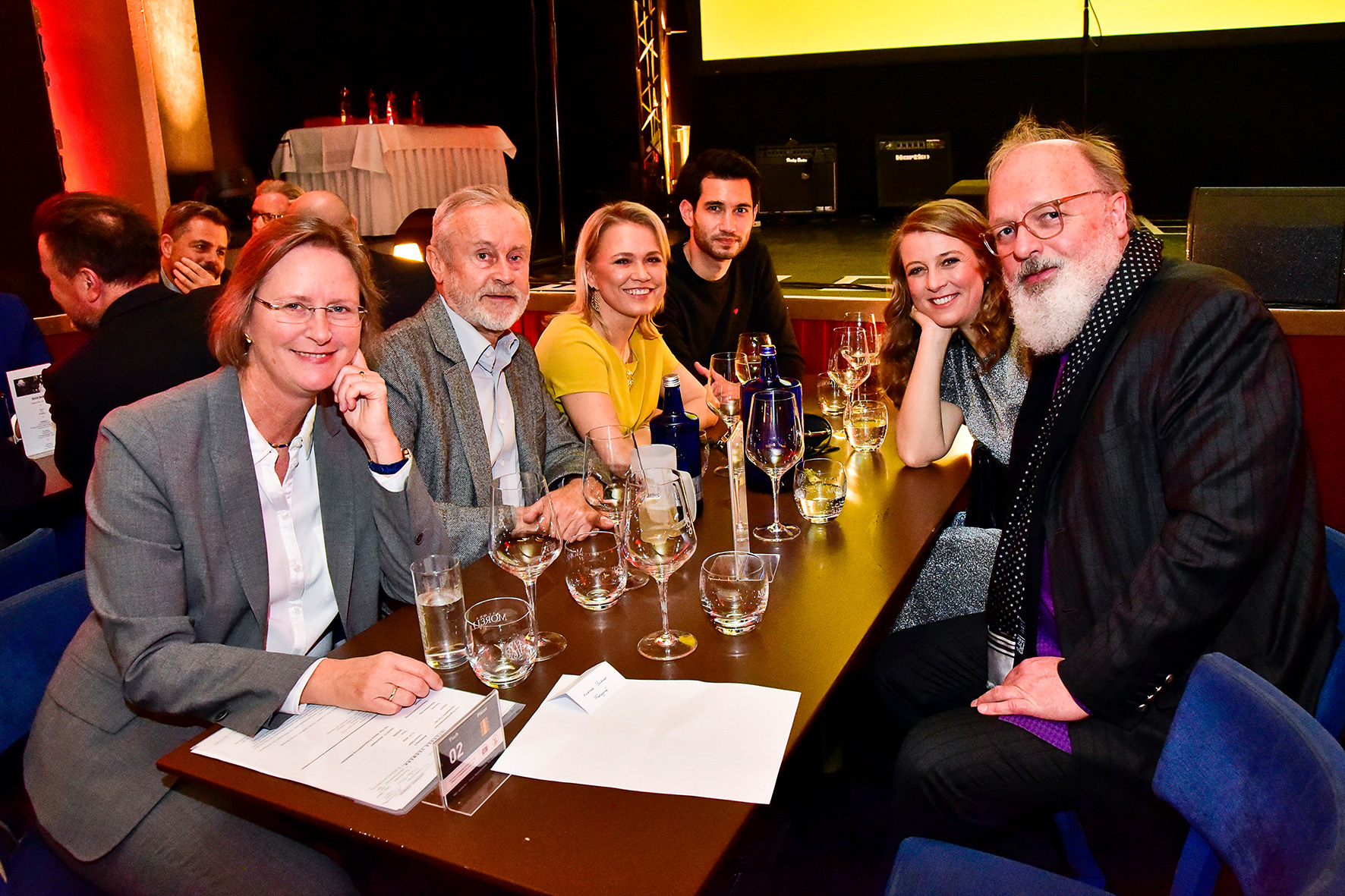 Tisch voller Gäste des Film-Awards lächelt in die Kamera