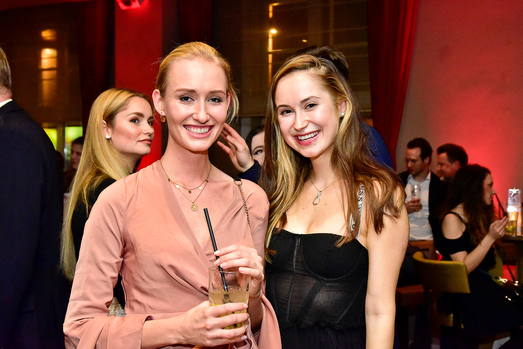 Zwei Frauen mit Drinks auf Party
