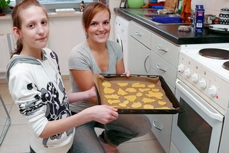 EIne Frau und ein Mädchen backen gemeinsam Plätzchen.