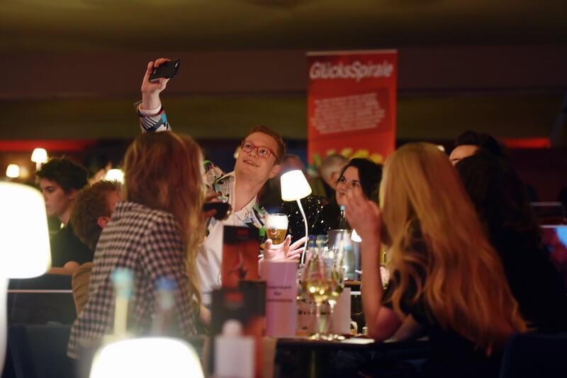 Menschen machen Selfies in einem Saal