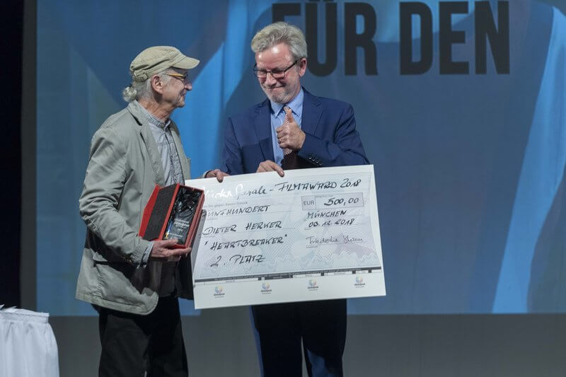 Zwei Männer mit Check und Award