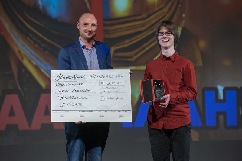 Zwei Menschen mit Check und Award