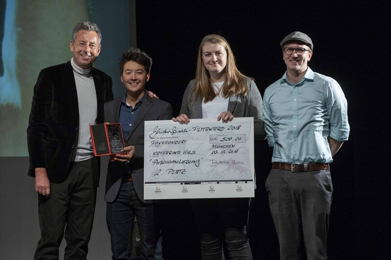 Vier Menschen mit Check und Award